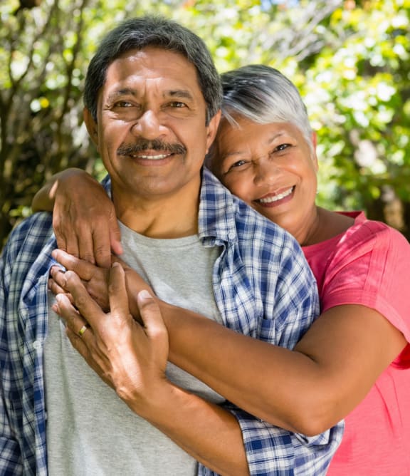 a man and a woman hugging each other in a park