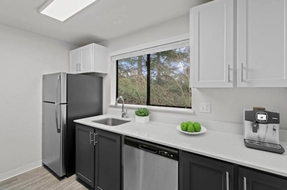 A kitchen with a black fridge and black cabinets  at Brackett Apartments, Edmonds, 98020