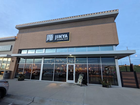 A JINYA storefront with a clear sky in the background.