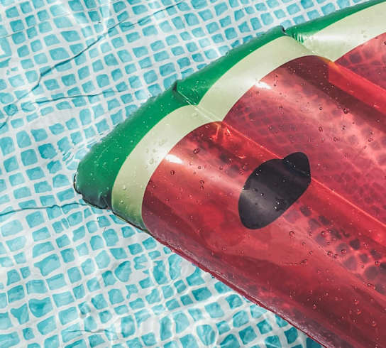 A red bottle with a green band and two holes in it.