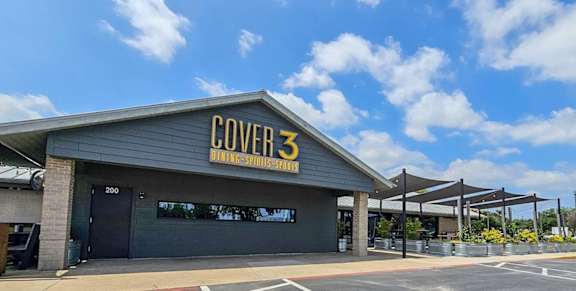 The image shows a building with the sign "COVER 3" on it.