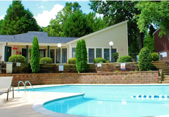 A swimming pool in front of a house with trees and bushes around it.at Creekside Canopy, Charlotte North Carolina