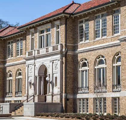 the front of a large brick building with a courtyard