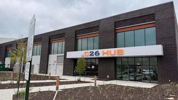 The C26 Hub is a modern building with a glass facade and a white entrance.