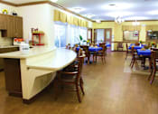 Thumbnail 5 of 6 - A kitchen with a counter and chairs.
