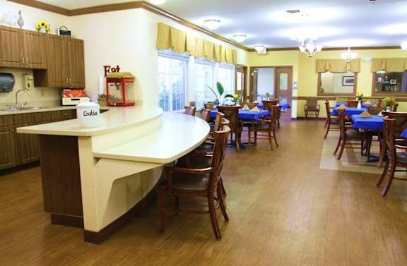 A kitchen with a counter and chairs.