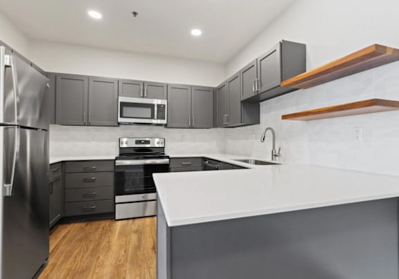 A modern kitchen with white cabinets and a black stove top.