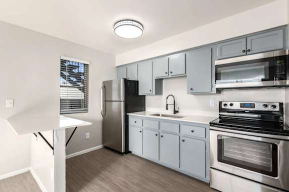 a kitchen with stainless steel appliances and white cabinets