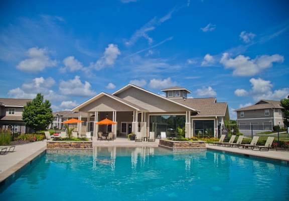 A large house with a pool in front.