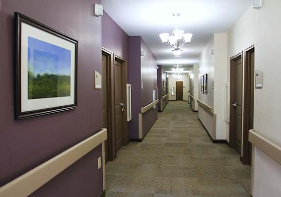 A hallway with brown doors and a painting on the wall.