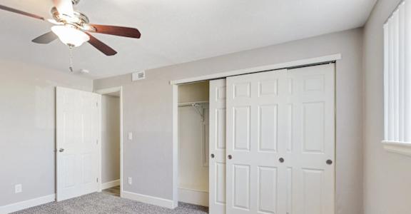 A room with a ceiling fan and two doors. at Park 146, Aurora, Colorado