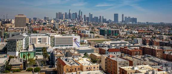 A cityscape with a mix of modern and older buildings under a clear sky.