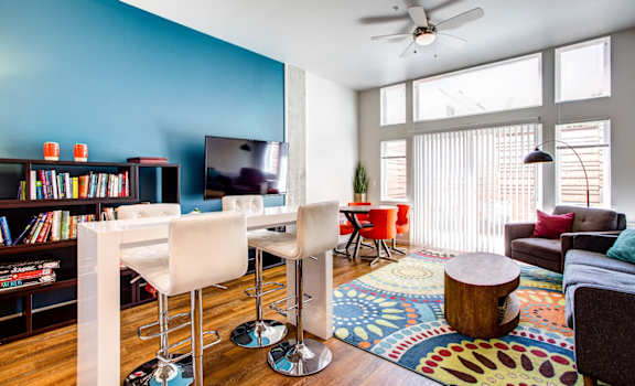 a living room with a blue accent wall and hardwood floors
