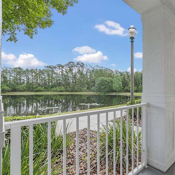 A brick building with a white porch and a black gate. at Northlake Park Apartments, Orlando