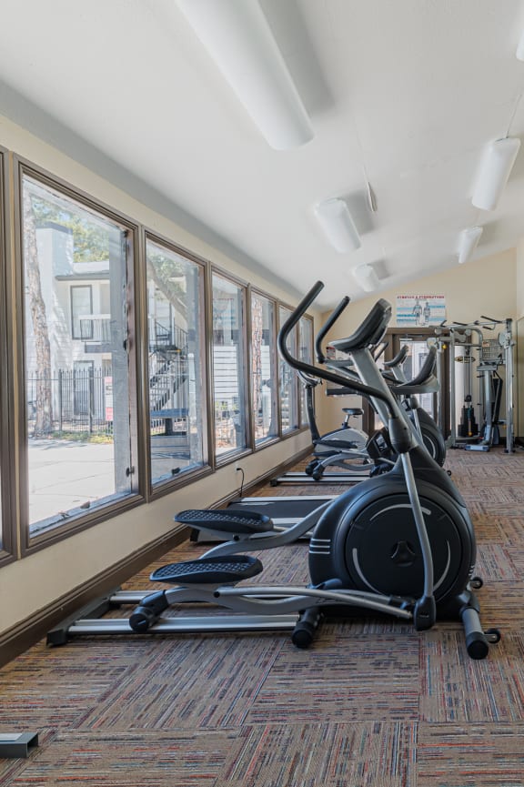 a gym with weights and cardio machines in it