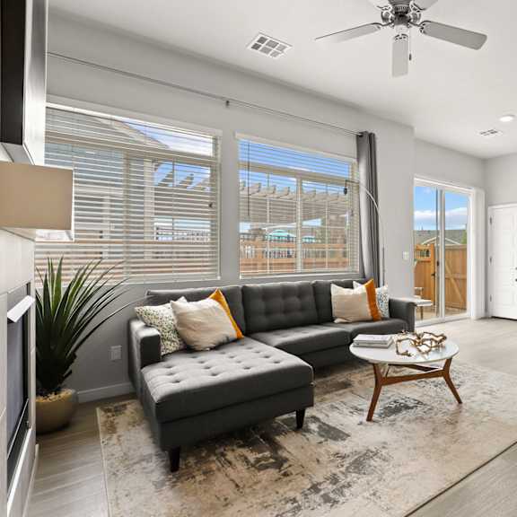 an open concept living room and dining area with a white dining table and rattan chairs