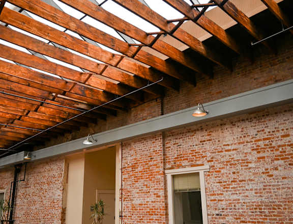 A room with a brick wall and a wooden ceiling.