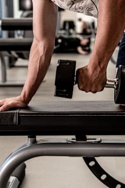 A man and a woman are exercising on treadmills in a gym.