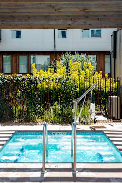 A small pool with a diving board and two chairs.
