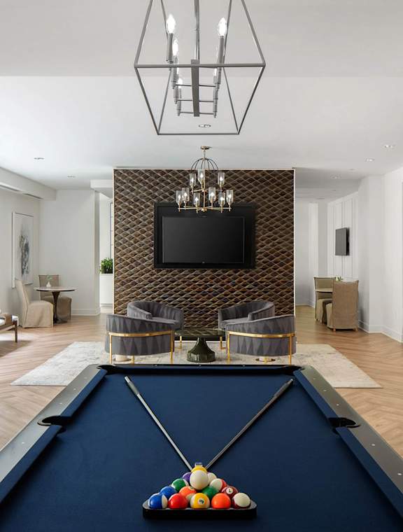 A pool table with balls set up in the corner of a room.