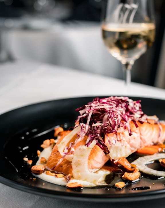 a plate of food and a glass of wine on a table