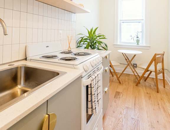 a kitchen with a stove and a sink and a window