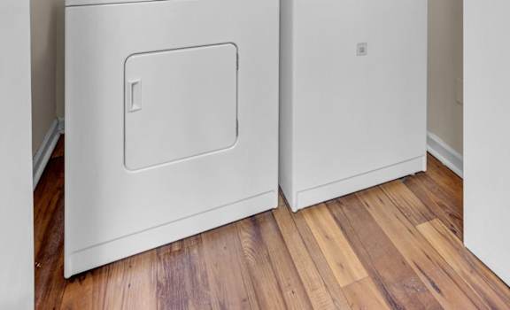 a washer and dryer in a room with a wood floor