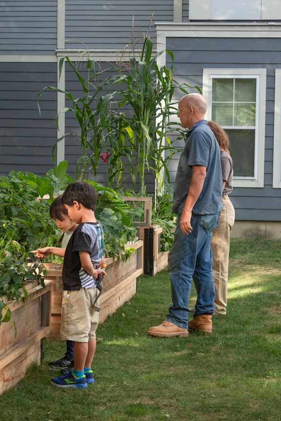 A man and a boy are standing in a garden.