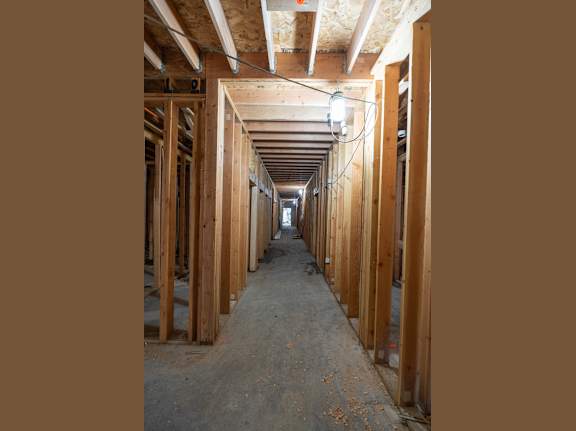 A long hallway with wooden walls and a concrete floor.