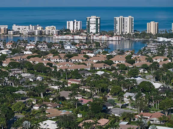 A coastal cityscape with a mix of residential and high-rise buildings.