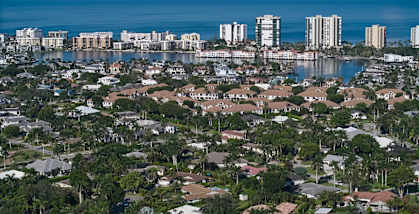 A coastal cityscape with a mix of residential and high-rise buildings.
