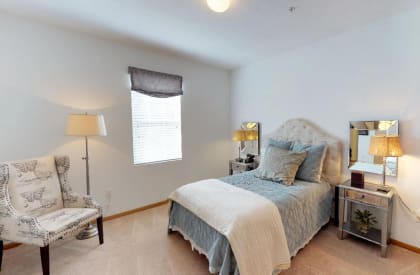a bedroom with a bed and a chair at Brookfield Village Apartments, Ohio, 43123