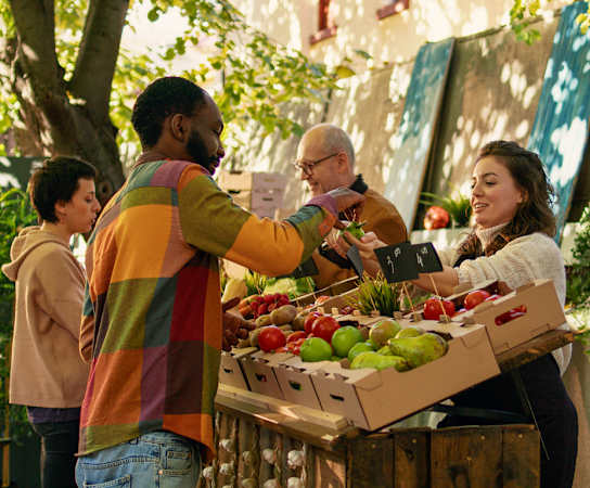 a group of people standing in front of a fruit stand at The Station at River Crossing, Macon, GA