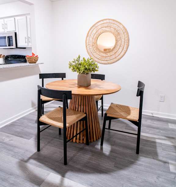 A round wooden table with four chairs around it.
