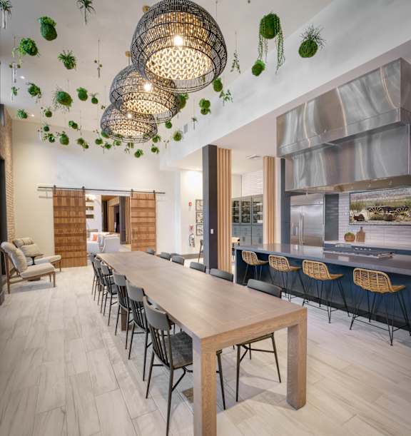 a dining room with a long wooden table and a kitchen at Lyric at Norton Commons Apartments, Prospect, Kentucky