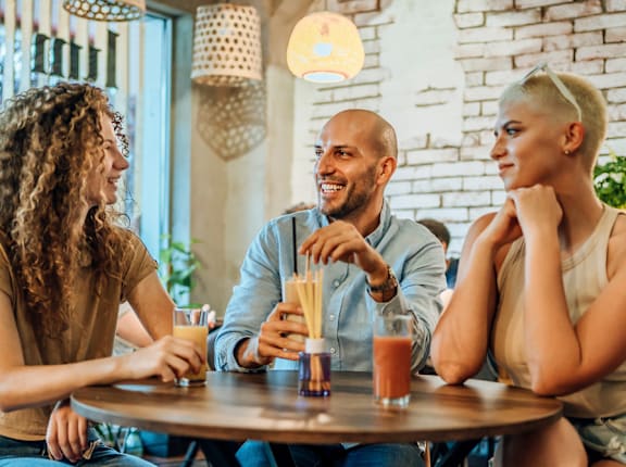 Three people are sitting at a table in a restaurant.