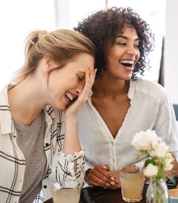 three women laughing at a table
