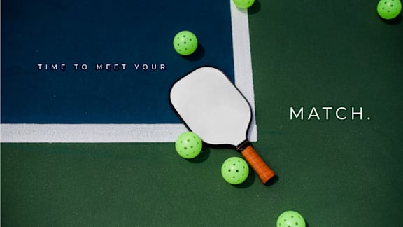 A green ball is in the air, about to be hit by a paddle.