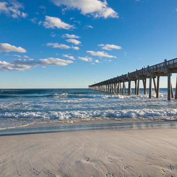a pier on the beach next to the ocean