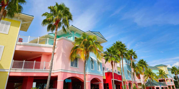 a row of colorful houses with palm trees in front of a blue sky at Portofino Vineyards Apartment, Fort Myers, FL, 33967
