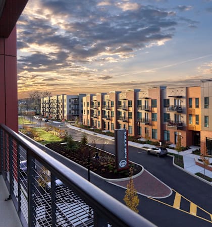 a rendering of an apartment building with a sunset in the background