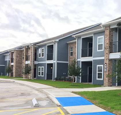 Apartment building with a blue painted area in front.