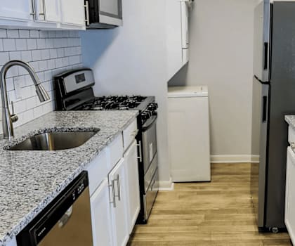 A kitchen with granite countertops and white cabinets.