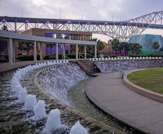 a water fountain with a bridge in the background at Candlewood, Texas, 78412