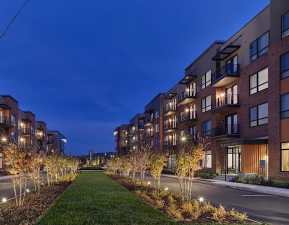 a row of apartment buildings on a city street at night