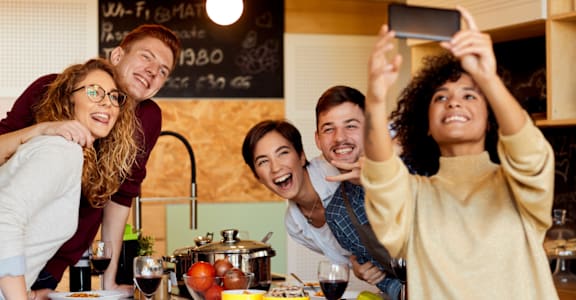 a group of people posing for a picture in a kitchen