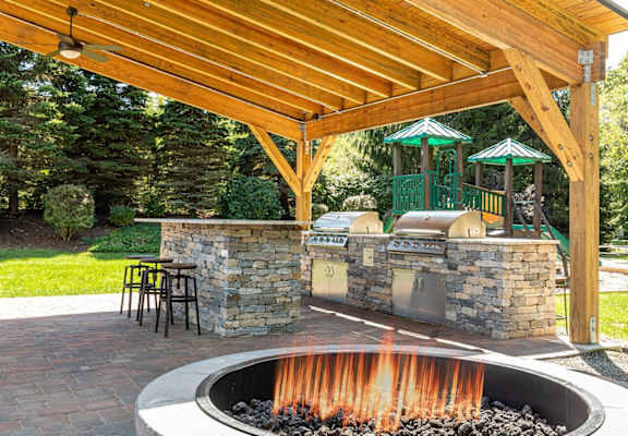 a backyard with a barbecue grill and a fire pit at The Ledges Apartment Homes, Groton, 06340