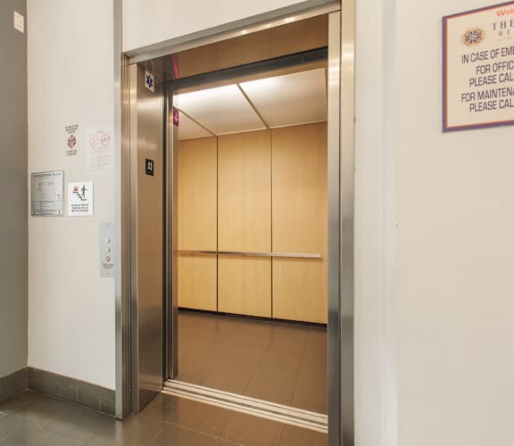 A sign on the wall instructs to call maintenance in case of an emergency.