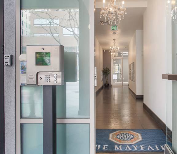 A hallway with a blue door and a sign that says "The Mayfair".
