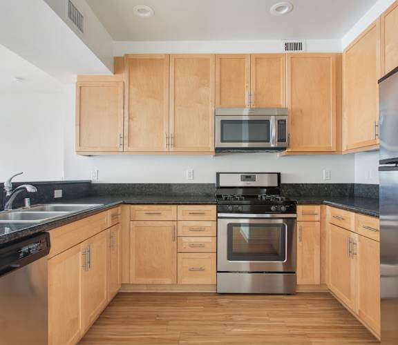 A kitchen with wooden cabinets and a black countertop.